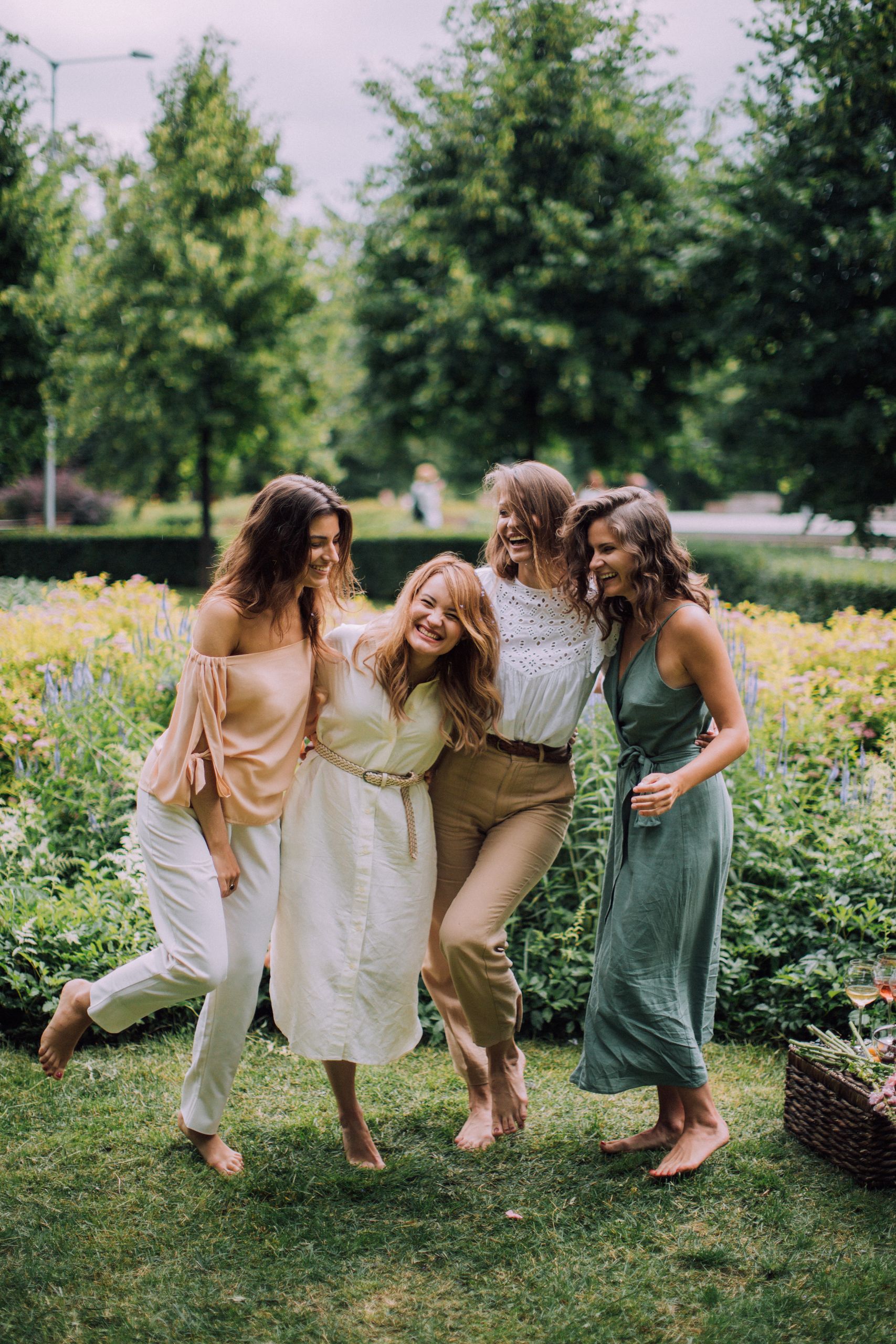 Femmes souriantes et complices en extérieur, illustrant l'accompagnement émotionnel et le bien-être féminin