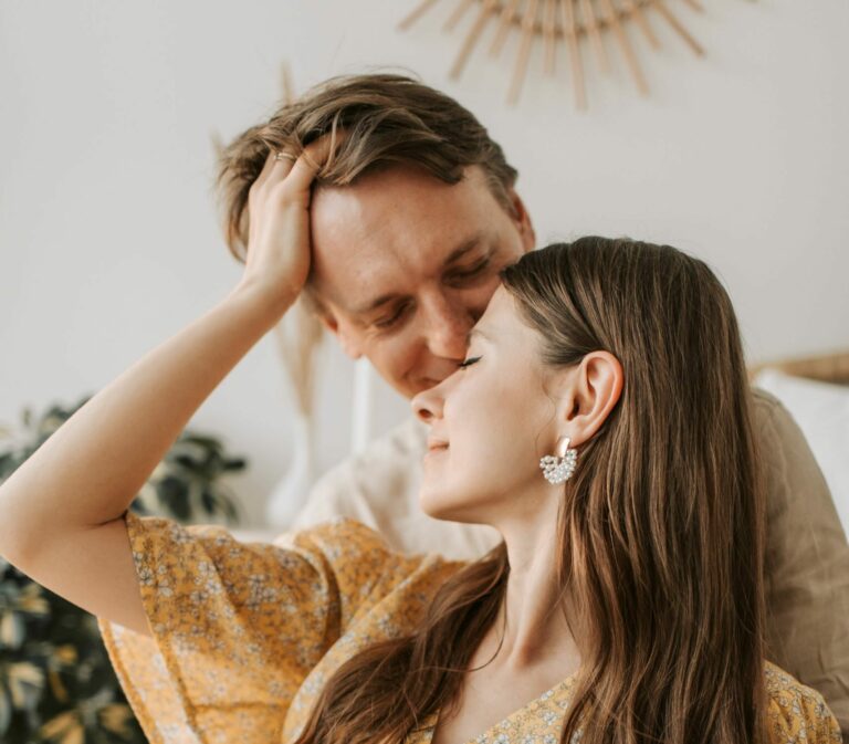 Tender moment with couple sharing an affectionate embrace, indoors, in warm tones.